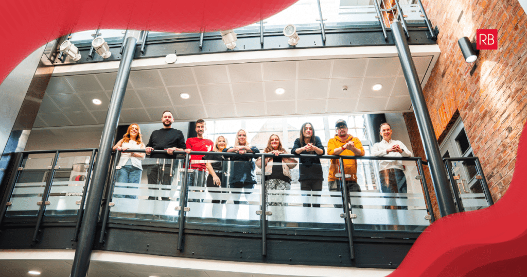 Red Box team members on a balcony looking down, image has branding swirls on corners